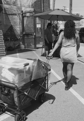 Jannine pulls boxes of free clothing in a wagon